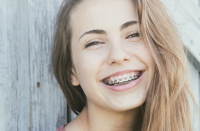 Young woman with traditional braces smiling