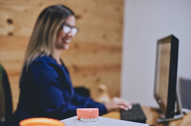 a dental receptionist typing on a computer