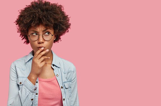 Woman on pink background wonders about Invisalign in Worcester 