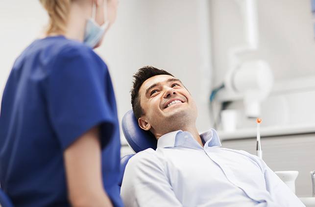 Man smiling at dentist during Invisalign consultation