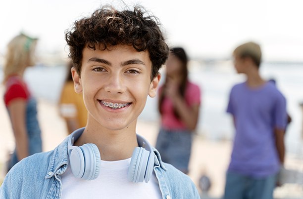 Boy smiling with headphones around his neck