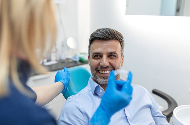 Middle-aged man visiting orthodontist to discuss clear aligners