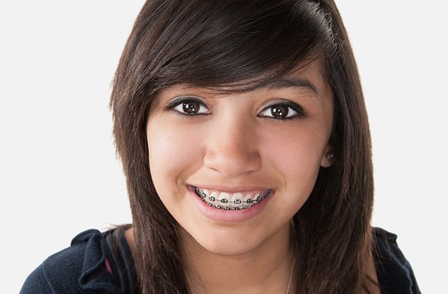 Preteen girl with pediatric orthodontics smiling