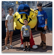 Children and smiley face mascot at sports event