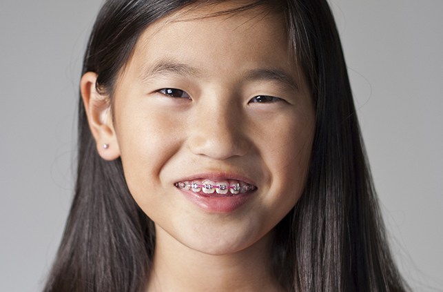Young girl with traditional braces smiling