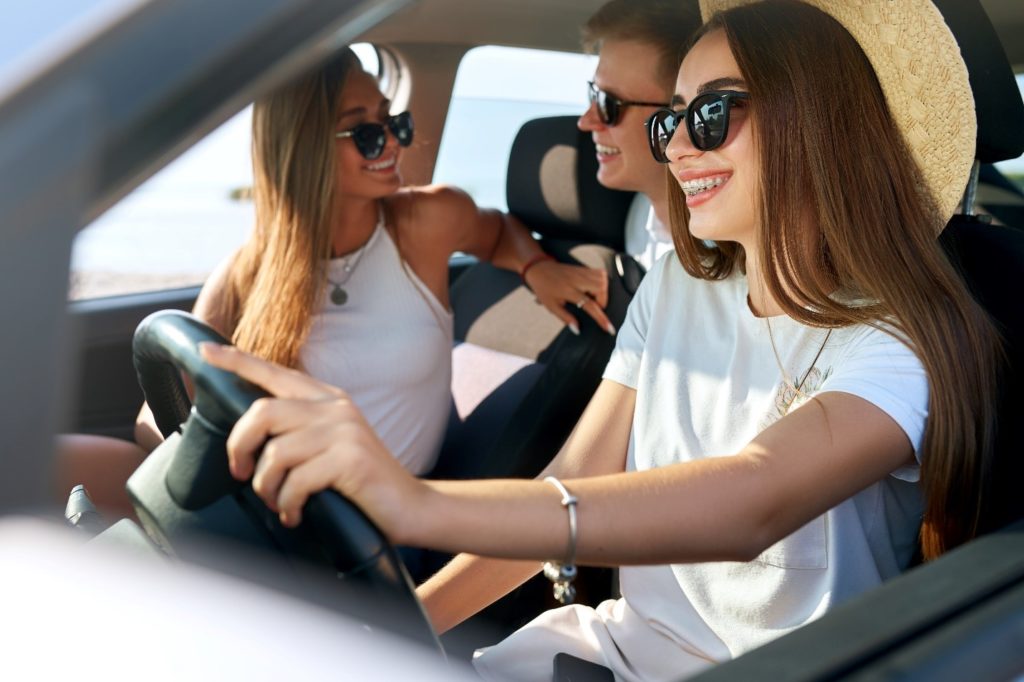 Girl with braces smiling on road trip with friends