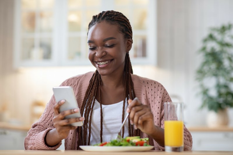 Woman with braces smiling while eating lunch