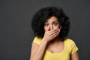 Woman with orthodontic relapse covering her mouth