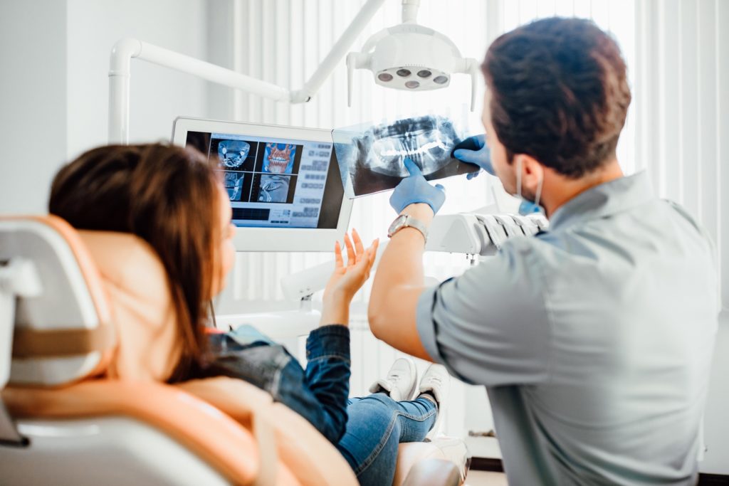 Orthodontist showing patient X-ray of their teeth