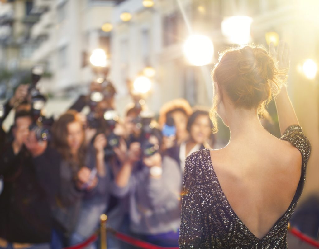 Paparazzi taking photos of celebrity on red carpet
