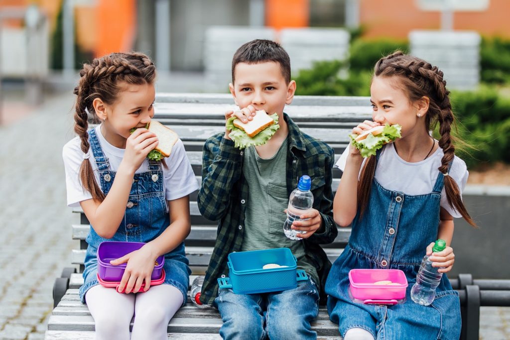 Group of kids eating lunch together at school