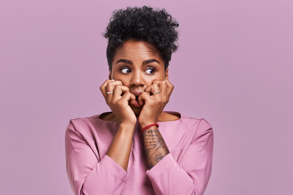 Closeup of woman in purple shirt looking worried