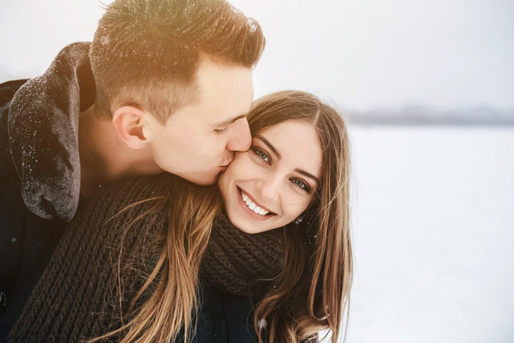 Man kissing woman on cheek in the snow