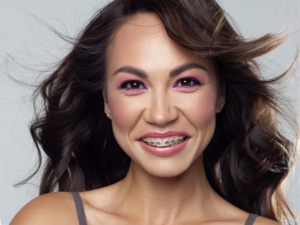 a patient with braces smiling confidently