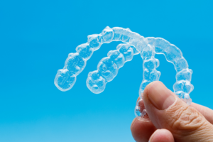 a closeup of a patient holding Invisalign trays